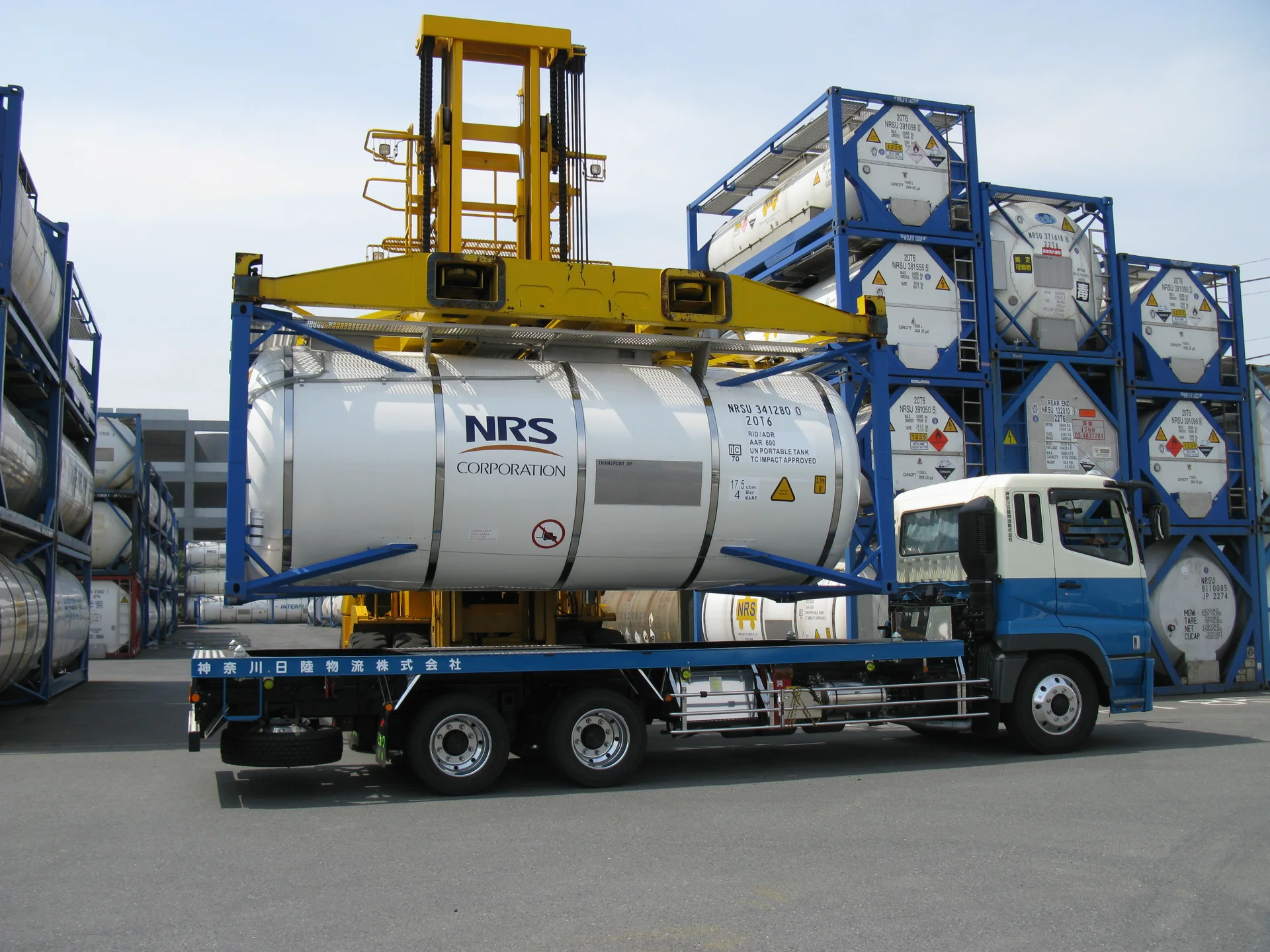 Industry photograph of an ISO tank container being loaded onto a road trailer.